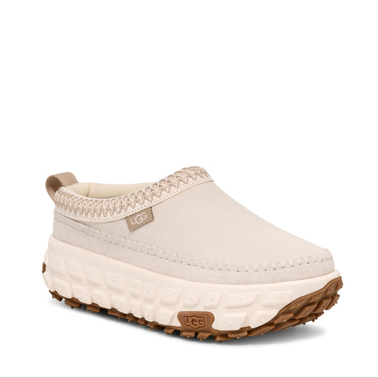A beige UGG Venture Daze slipper with a suede upper and a grippy outsole, designed for both men and women.