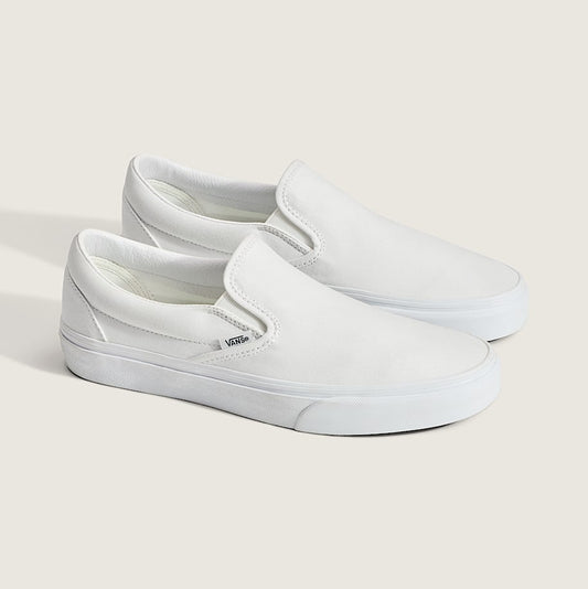 White slip-on sneakers on a light gray background