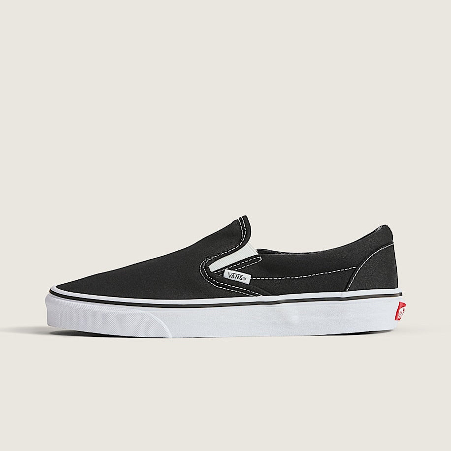 Black slip-on sneaker with white sole on a light gray background