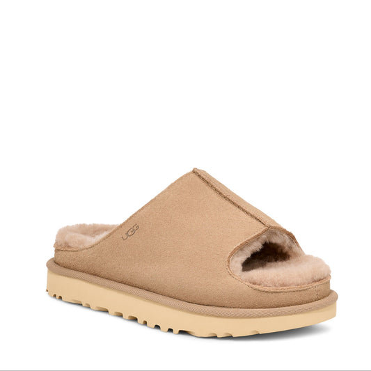A women's UGG Greenport Slide in brown color, showcasing the side profile of the slipper with the brand's logo visible.